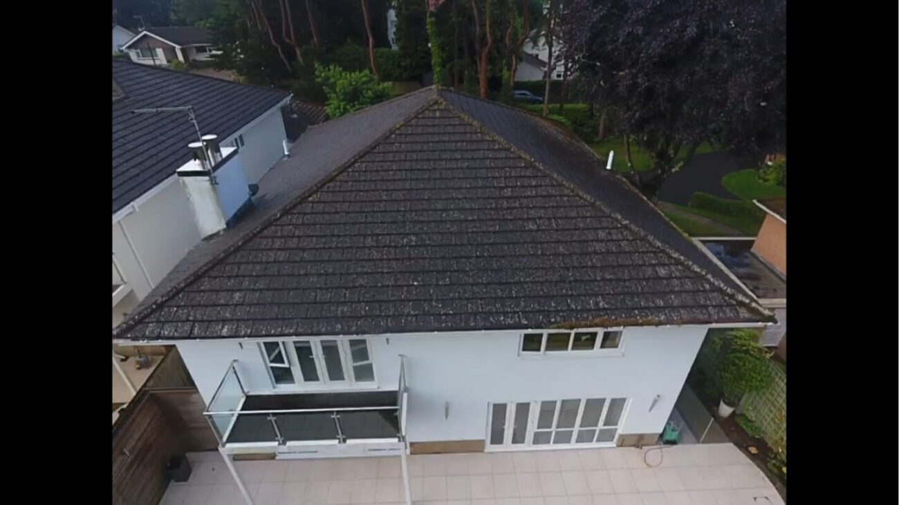 rear view of white uk home with dirty roof in need of restoration