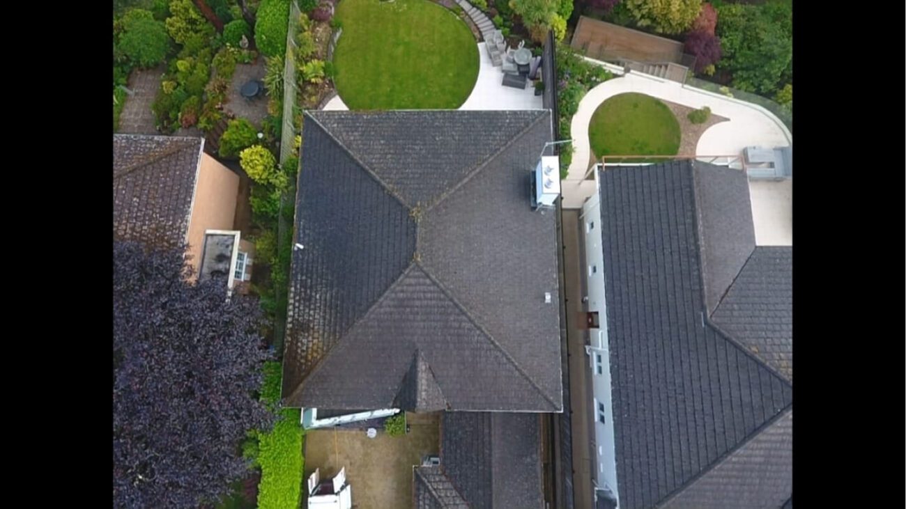 top down view of grey tiled roof covered in filth, moss and grime