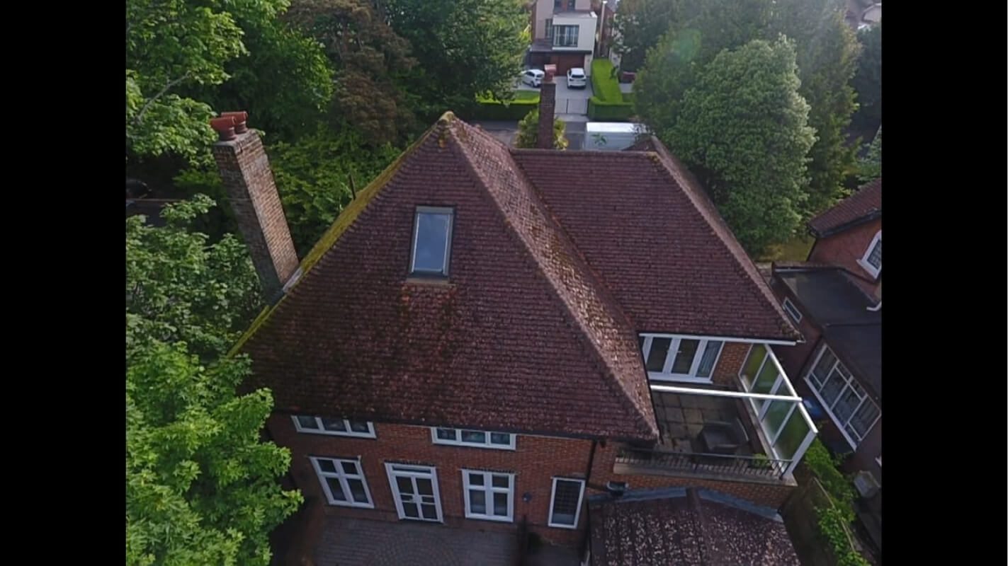 rear view of red tiled roof covered in moss with balcony