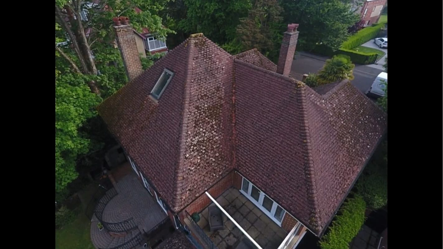 Aerial view of red tiled roof in wooded residential area