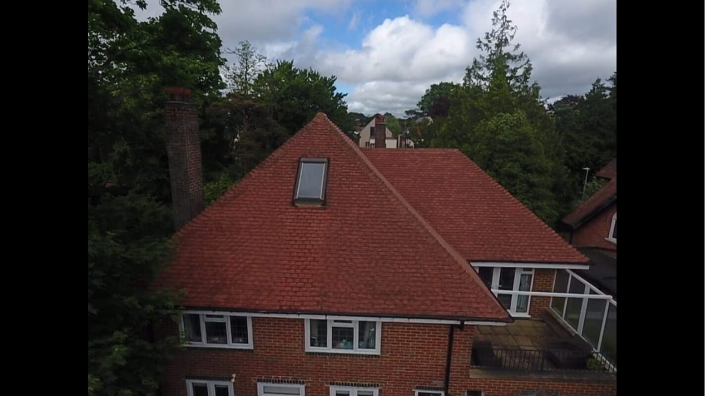 Red brick home with recently soft washed roof and balcony