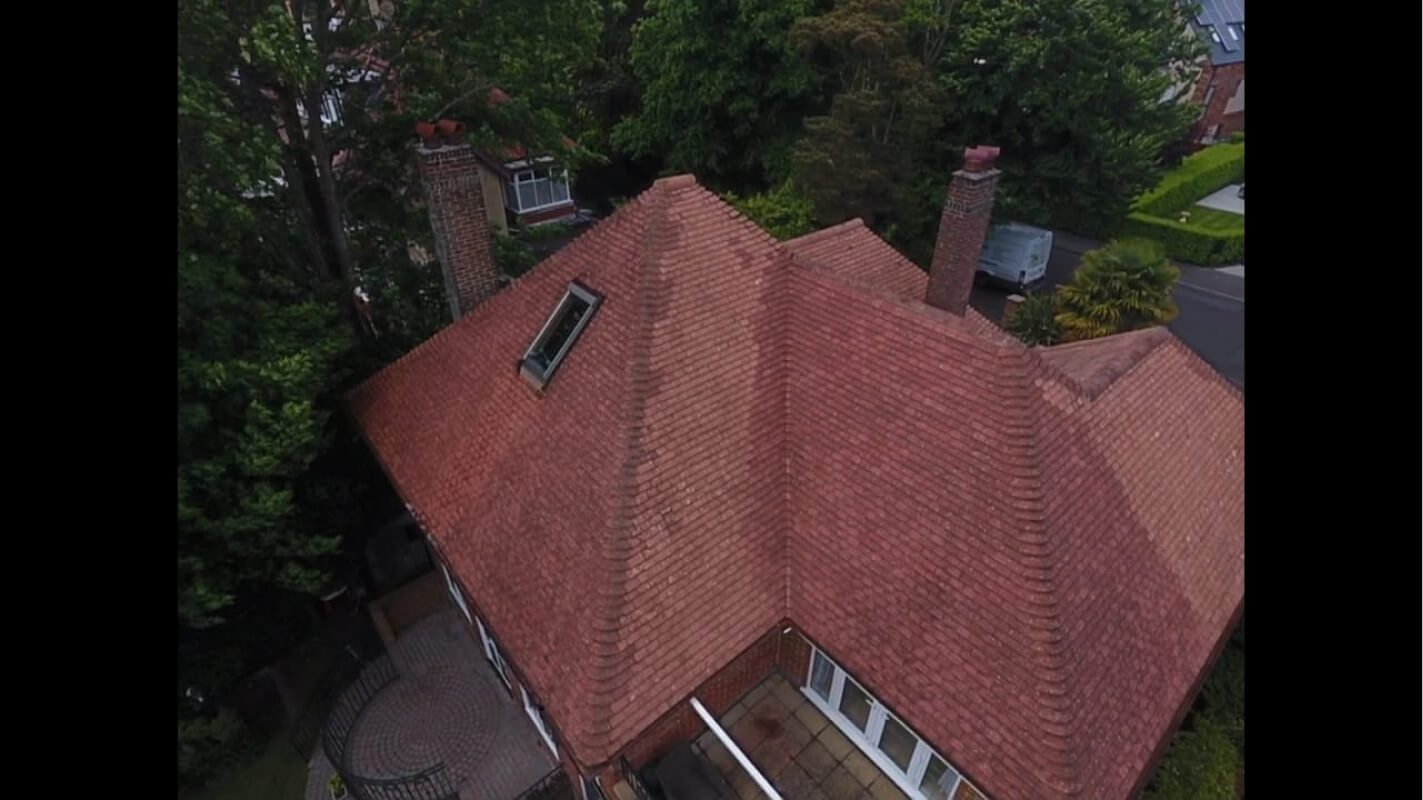 rear view of red tiled roof that was soft washed drying in Dorset