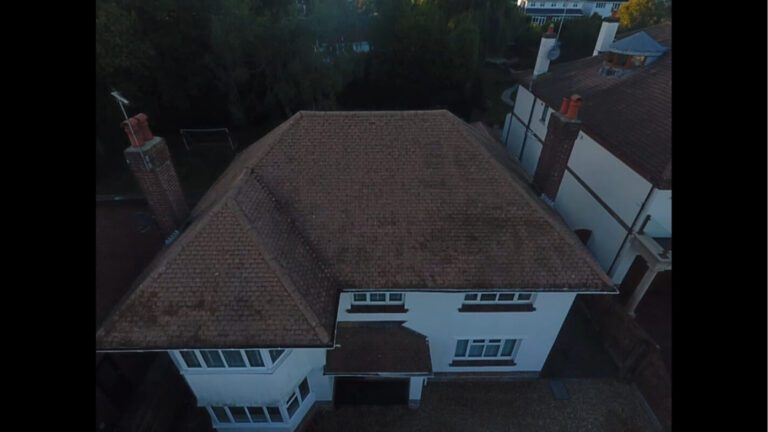 Recently cleaned home with red tiled roof and two chimneys