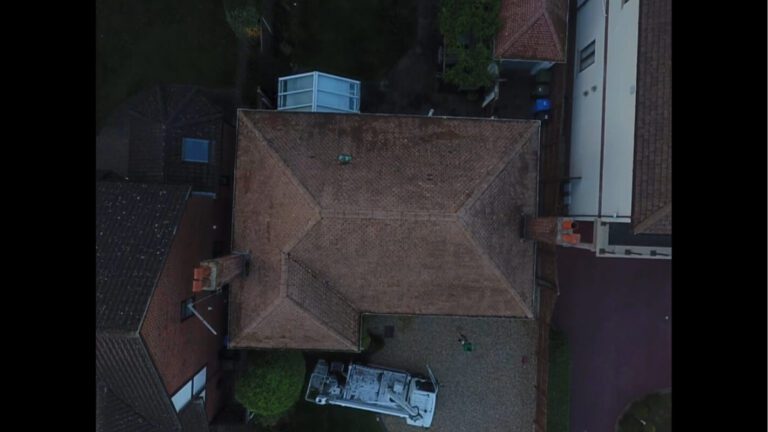 Aerial top down view of recently soft washed roof with two chimneys