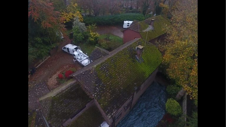 diagonal view of uk home with tiled roof covered in moss