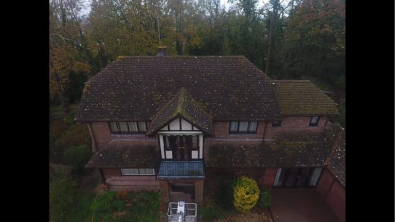 Frontal view of dirty UK home covered in moss