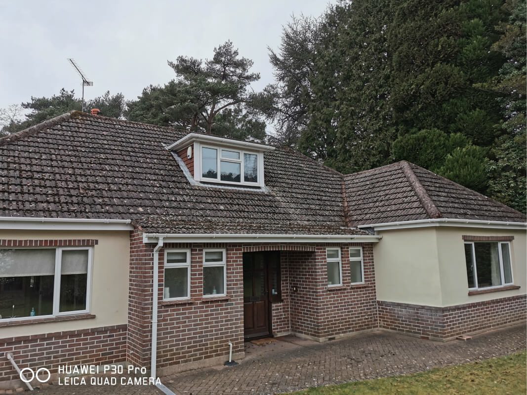 front view of bungalow with moss covered roof