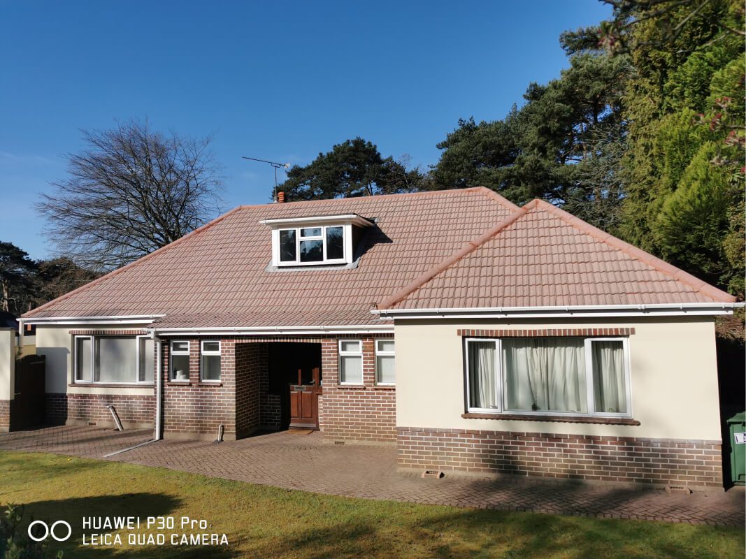 Bungalow with cleaned roof and gutter shining in the sun