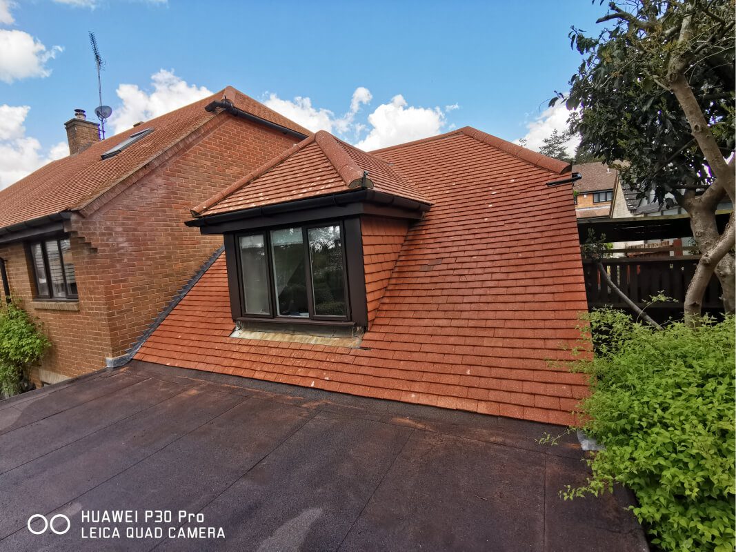 Red shingle roof soft washed after being dirty