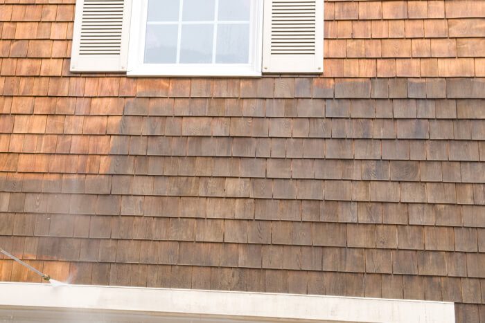 External wall shingles being cleaned via washing nozzle