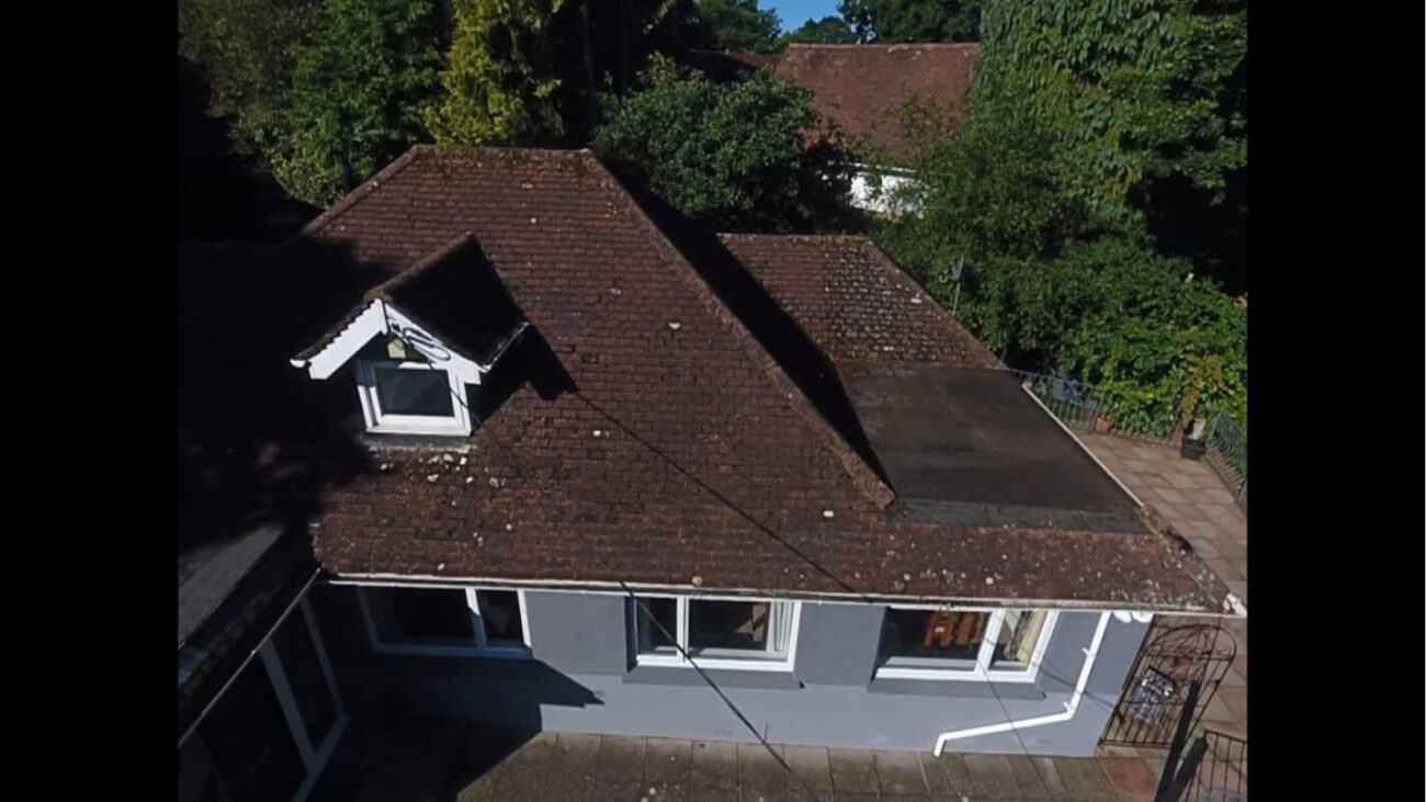 grey uk bungalow with dirty roof in need of restoration