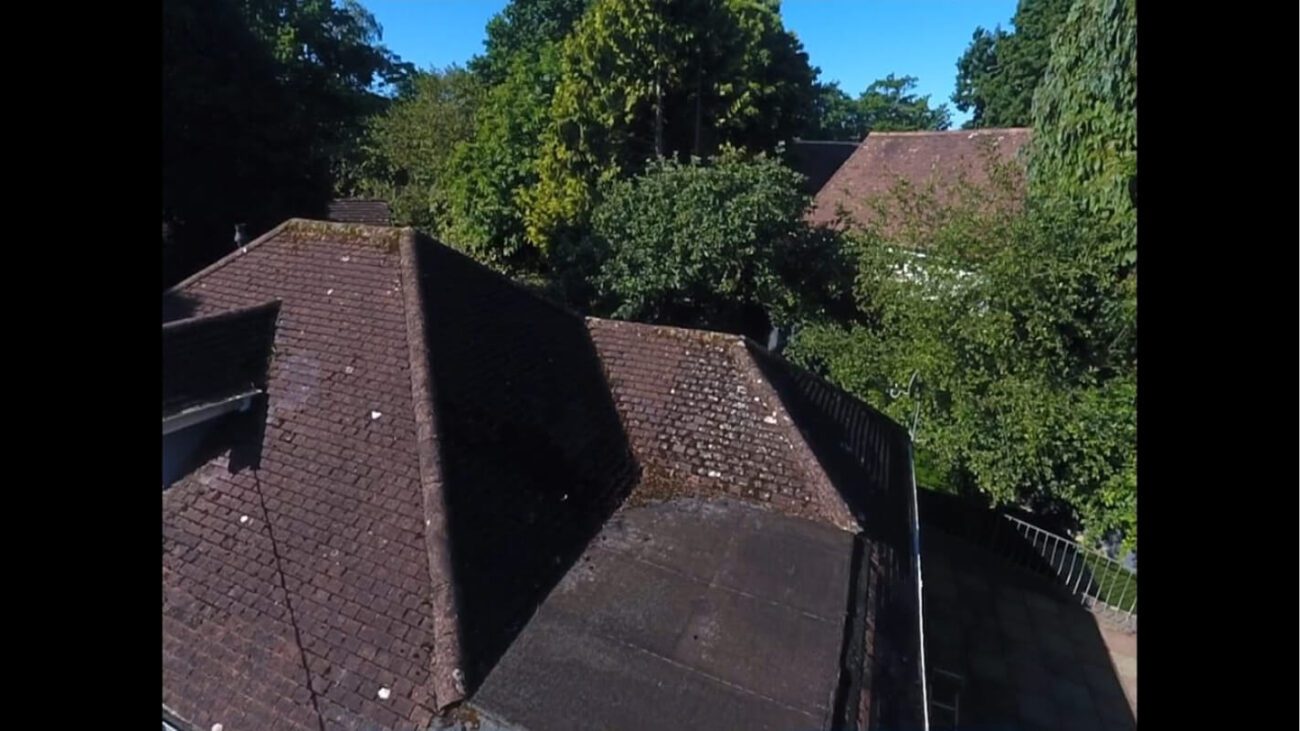 Uneven roof prior to cleaning covered in moss and dirt