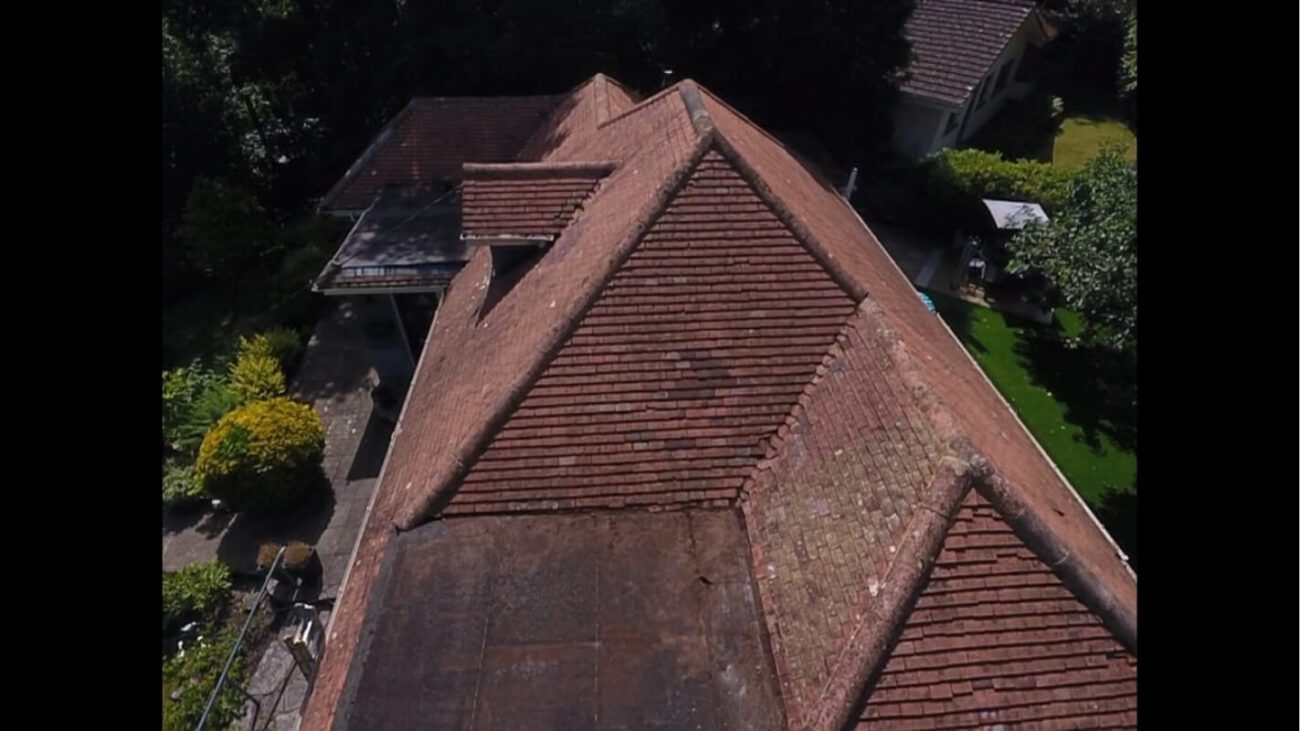 dry red roof tiles in process of being cleaned with soft wash formula