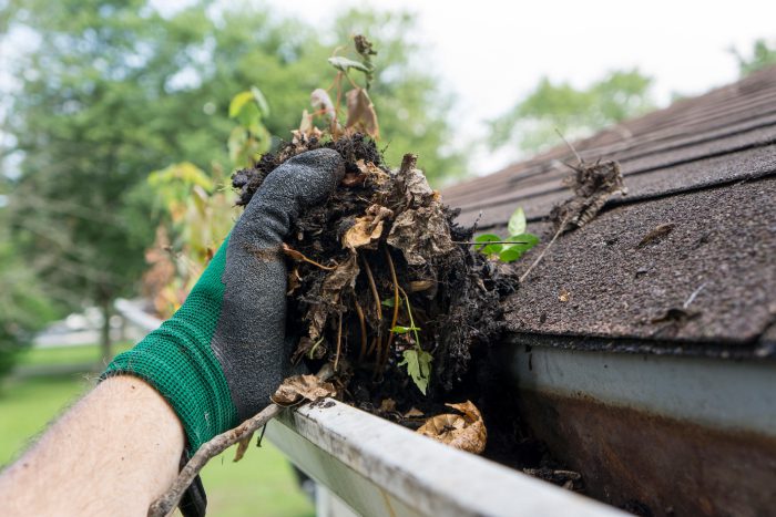 removing excess mud and dirt from residential gutters